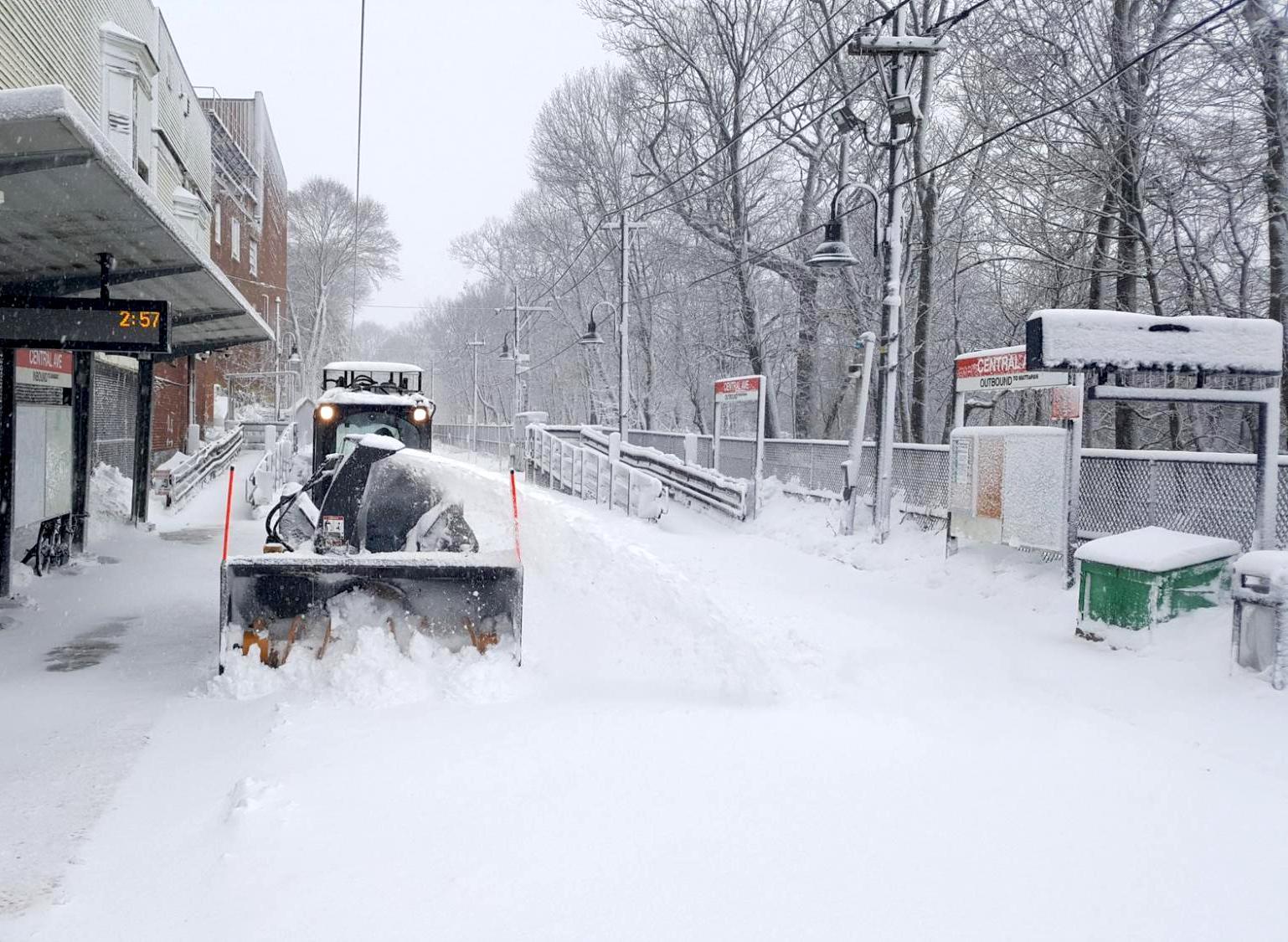 A plow clears snow from the tracks at Central Ave Station on the Mattapan Line