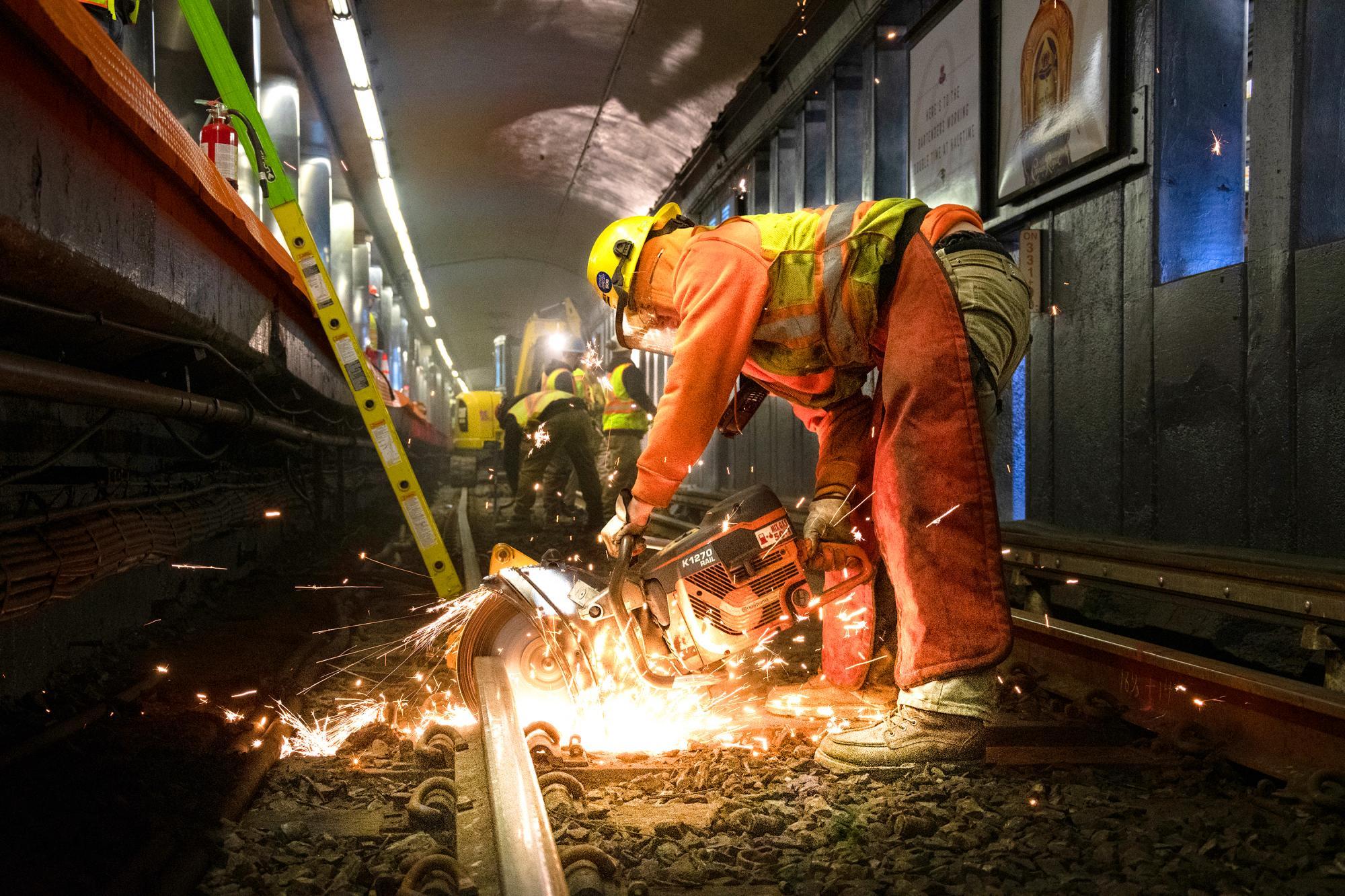 A crew member cuts track at Haymarket as part of rail replacement during the first Orange Line weekend shutdown of 2020
