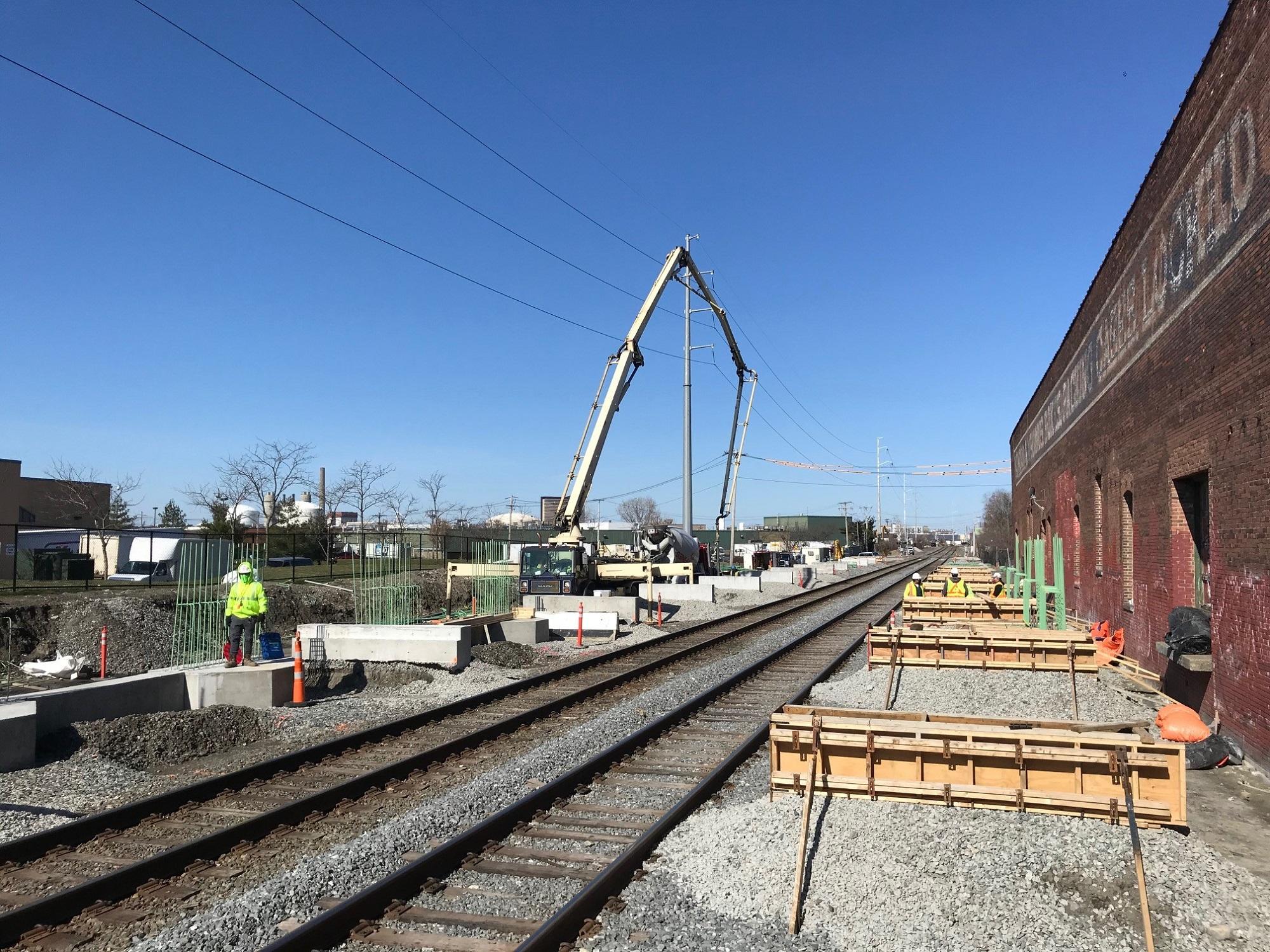 Crew members place concrete for Track 2 pile caps and canopy bases at Chelsea Commuter Rail Station, April 2020