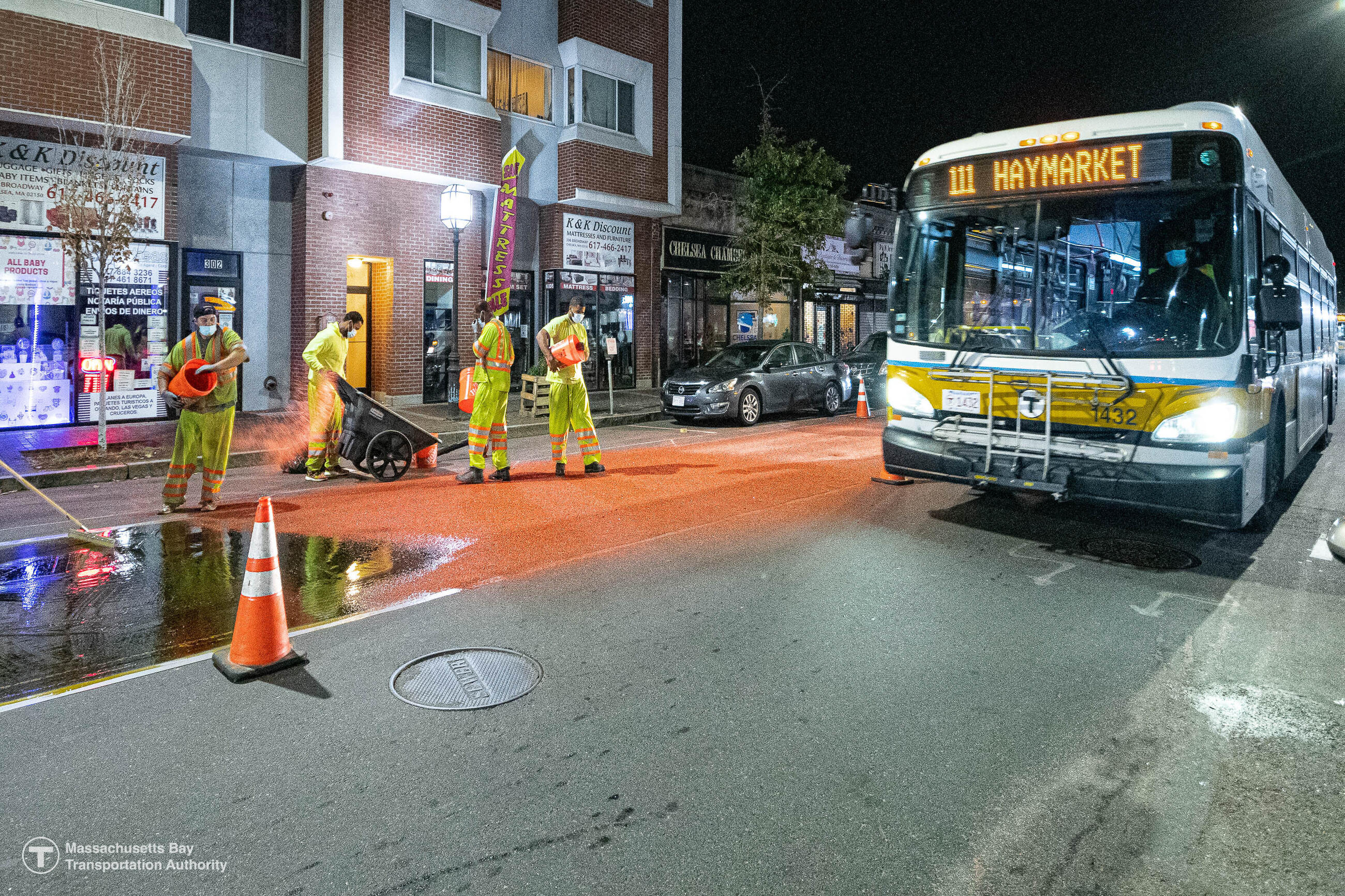 Crews install the shared bus/bike lane on Broadway in Chelsea as the 111 bus passes by