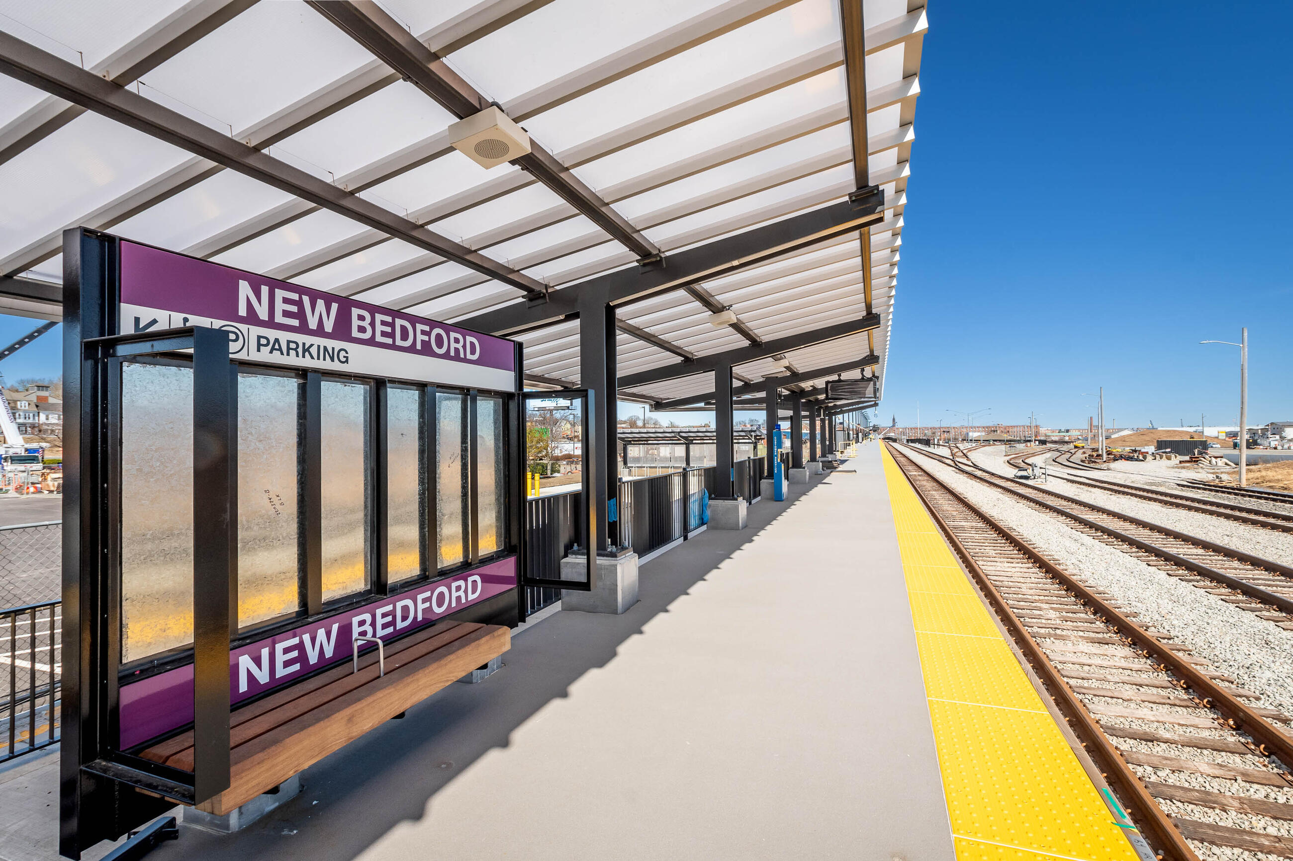 Newly renovated New Bedford station with station sign and platform with yellow tactile surface indicator 