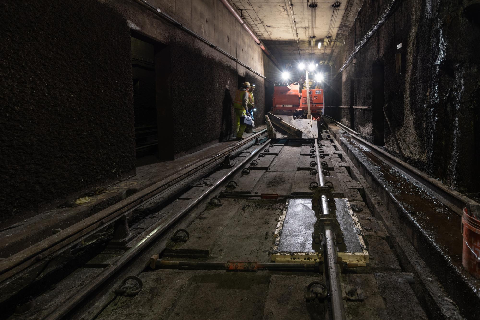 A crew works on maintenance in a tunnel