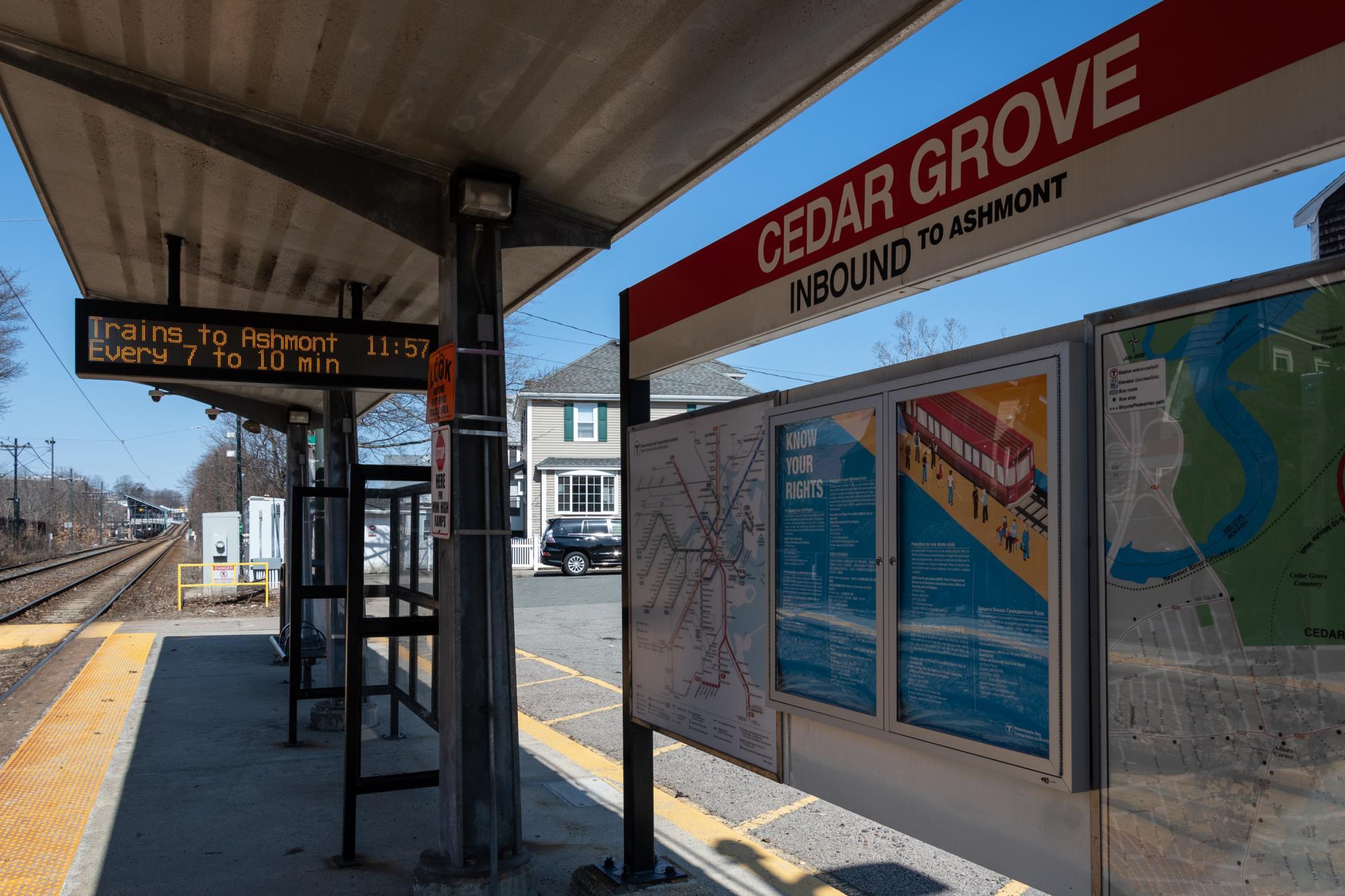 The station sign, maps, and coundown clock on the platform of Cedar Grove Station on the Mattapan Line
