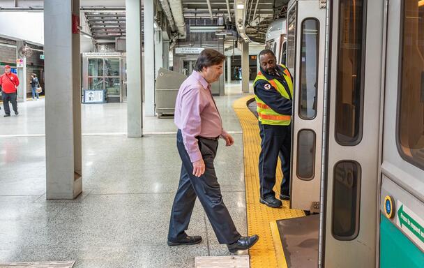 A green line inspector deploys the onboard ramp for a rider